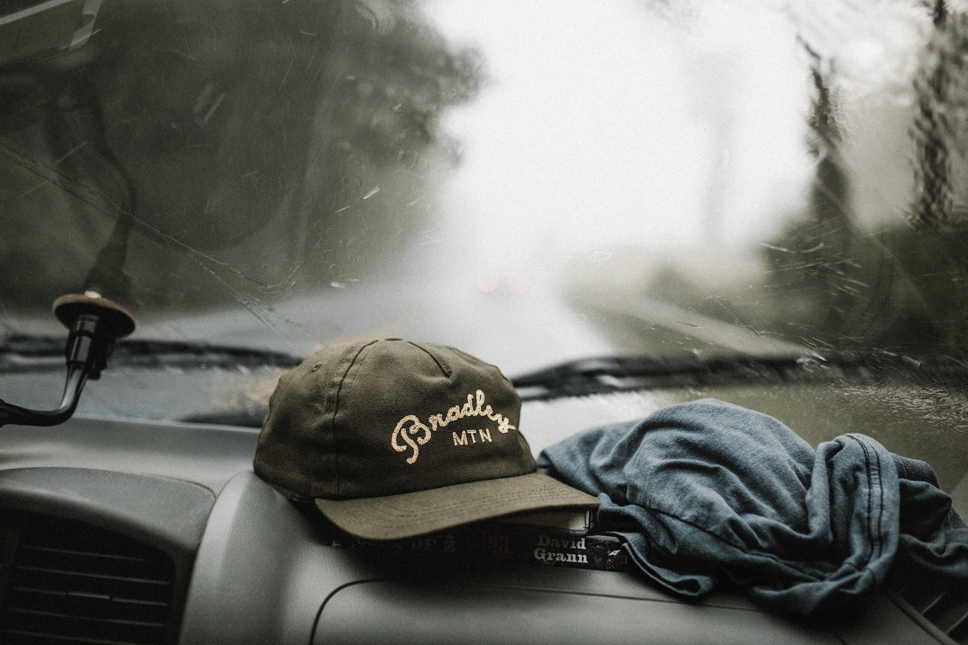 A 5 panel hat sits on the dashboard of a car